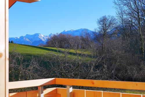 a view of a field and mountains from a porch at Ferienwohnungen beim Sommermader - inklusive Königscard in Nesselwang