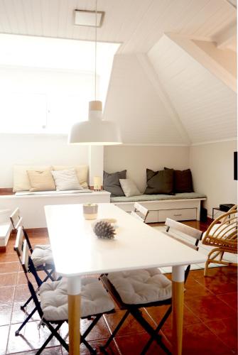 a white dining room with a white table and chairs at Old Town Apt with Ocean Views in Sesimbra