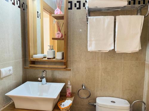 a bathroom with a sink and a toilet and towels at casa muralla - plaza mayor in Ciudad-Rodrigo
