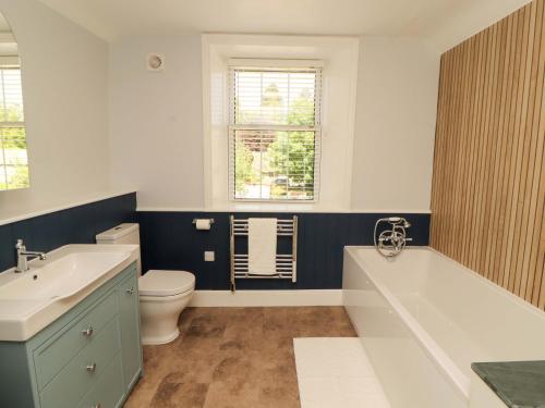 a bathroom with a tub and a toilet and a sink at East View in Kirkby Stephen
