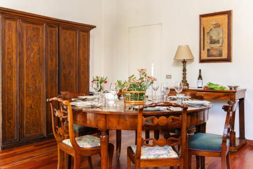 a dining room with a wooden table and chairs at Villa La Limonera in Casciago