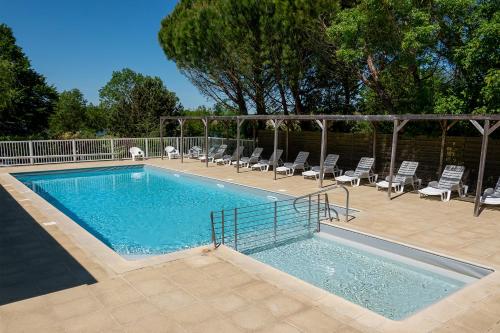 a large swimming pool with chairs at Camping les Coteaux du Lac in Chemillé-sur-Indrois