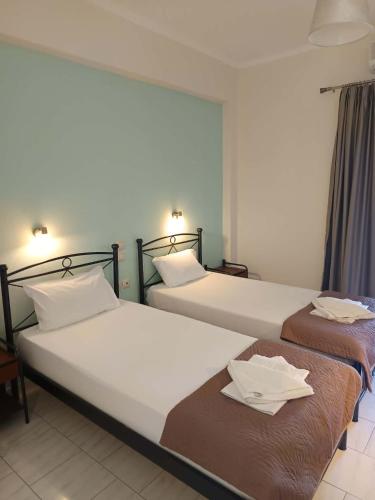 two beds sitting next to each other in a room at Odysseus Apartments in Agios Gordios