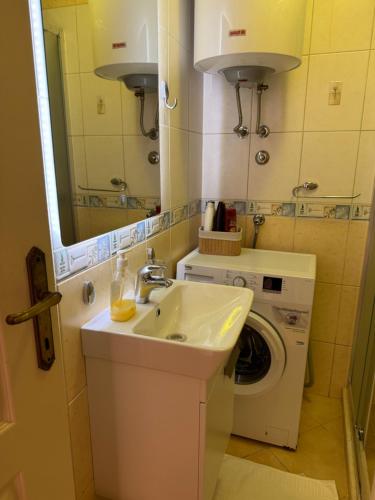 a bathroom with a sink and a washing machine at Apartments Popovic 2 in Kotor