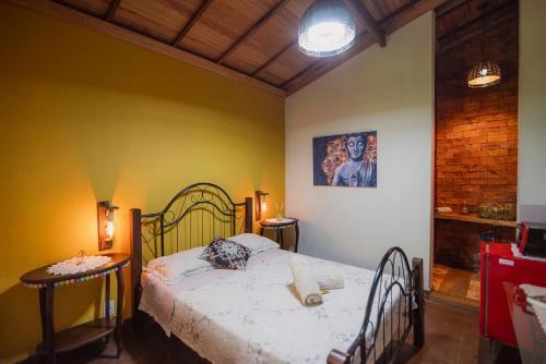 a bedroom with a bed and a table in it at Chalé das Flores in Brumadinho