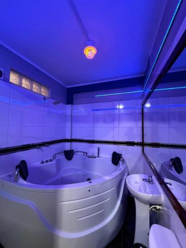 a bathroom with a white tub and a sink at Horus Suite Hotel in Jaén