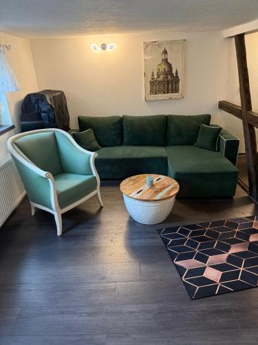 a living room with a green couch and two chairs at Ferienwohnung Mutzelmann in Kurort Gohrisch