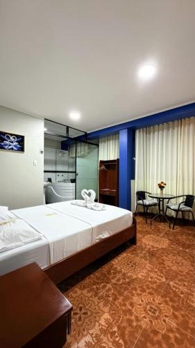 a bedroom with a large bed and a table at Horus Suite Hotel in Jaén