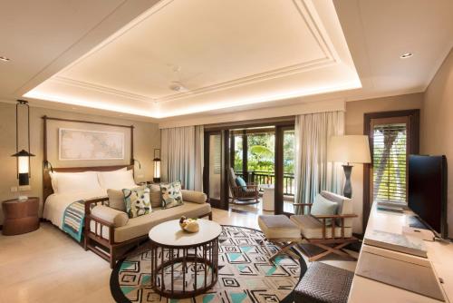 a hotel room with a bed and a television at Constance Lemuria in Grand'Anse Praslin