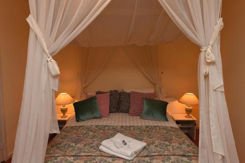 a bedroom with a canopy bed with two lamps at Motel Koolen in Velp