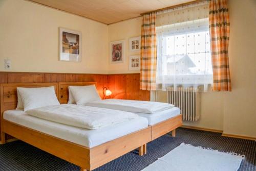 two twin beds in a room with a window at Alpenblick-Raggal in Raggal