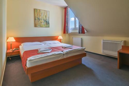 a bedroom with a large bed with two towels on it at Lipa Hotel és Étterem in Szentgotthárd