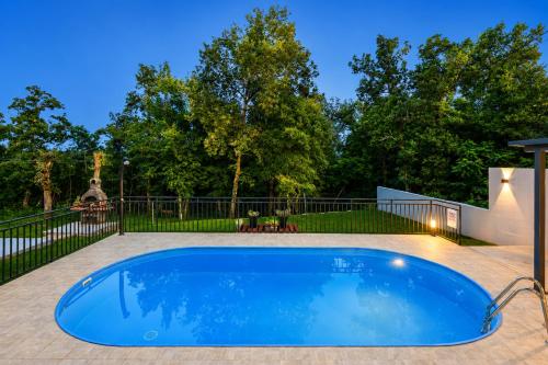 a swimming pool in a yard with a fence at House Luka by Briskva in Krapan
