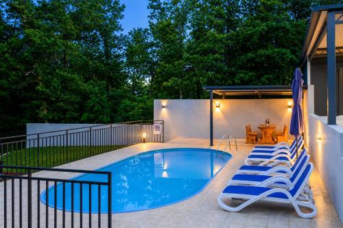 a swimming pool with lounge chairs and a table at House Luka by Briskva in Krapan