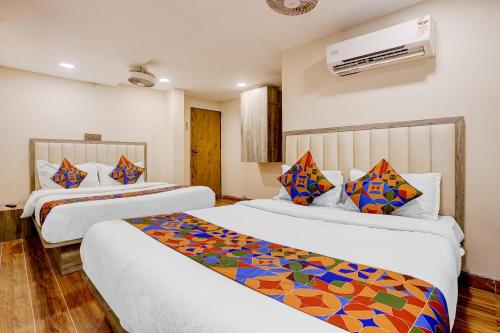 a hotel room with two beds with colorful pillows at FabHotel Pride Suitz in Mumbai