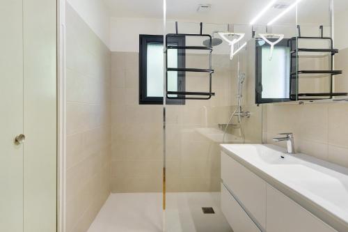 a bathroom with a glass shower and a sink at La Clémenguite in Vals-les-Bains