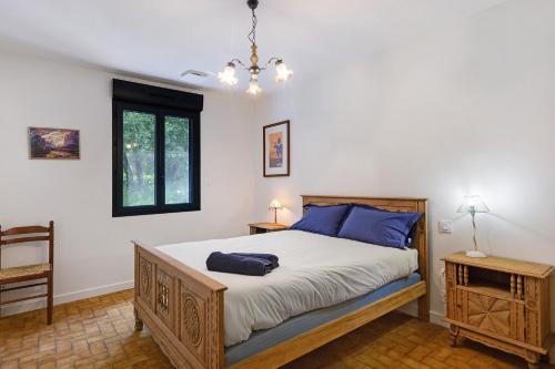 a bedroom with a bed with blue pillows on it at La Clémenguite in Vals-les-Bains