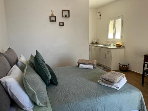 a room with a bed with pillows and a kitchen at Poseidon Beach Bar & Restaurant Apartments in Paleokastritsa