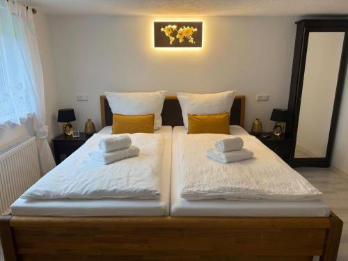 a bedroom with a bed with white sheets and yellow pillows at Ferienwohnung Mutzelnest in Kurort Gohrisch