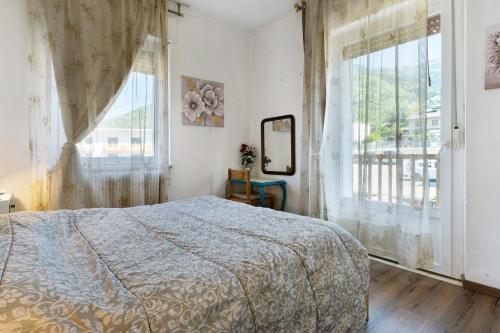 a bedroom with a bed and a large window at Casa Rosa in Levico Terme