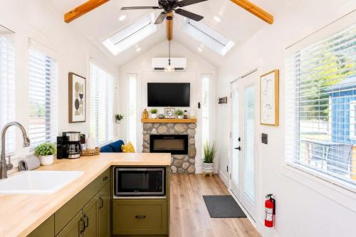 a kitchen with a sink and a fireplace at Near Zion Modern Tiny Home Hiking & MTB Access in Apple Valley