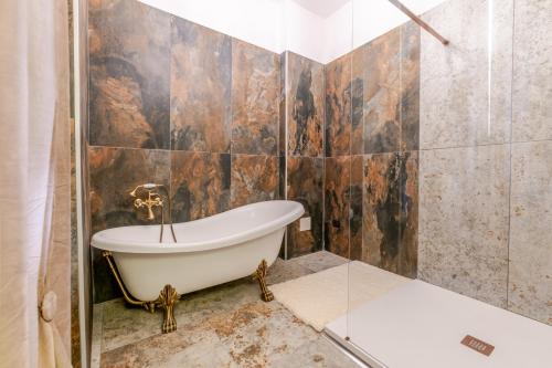 a bathroom with a tub and a shower at Ospitalità Deluxe Castello Vassallo in Stella Cilento