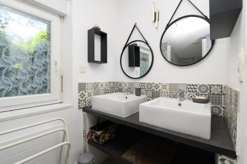 a bathroom with two sinks and a mirror at Domaine des légendes in Plumelin