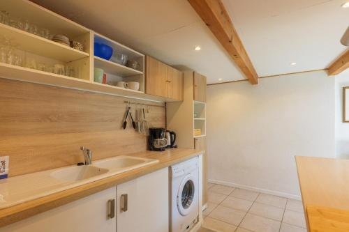 a kitchen with a sink and a washing machine at Élégant T3 Terrasse & Wifi in Vals-les-Bains