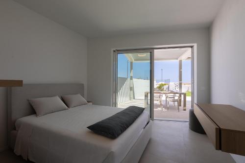 a bedroom with a bed and a balcony with a table at Residenze Da Vinci Azzurro in Senigallia