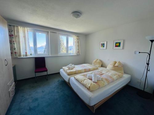 a bedroom with a large bed and a red chair at Chalet Vallese Valbella Lenzerheide, great view in Valbella