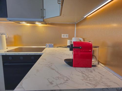a kitchen with a red appliance sitting on a counter at L'écrin De Mouroux - Disney 20 min - Clim & Parking in Mouroux