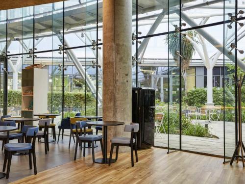 a restaurant with tables and chairs in a building at Aparthotel Adagio London Brentford in Brentford
