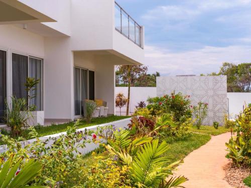 a white house with a garden in front of it at Nungwi Dreams by Mantis in Nungwi