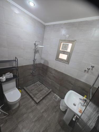a bathroom with a toilet and a sink at Khiran City in An Nāmī