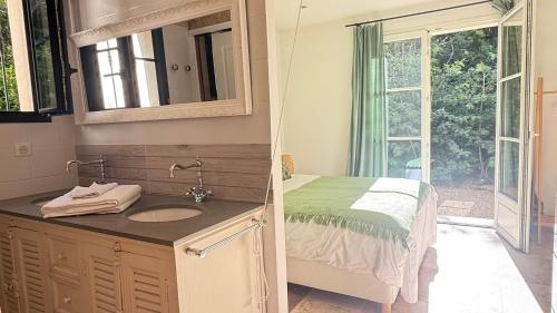 a bathroom with a bed and a sink and a mirror at La Largarde in Six-Fours-les-Plages