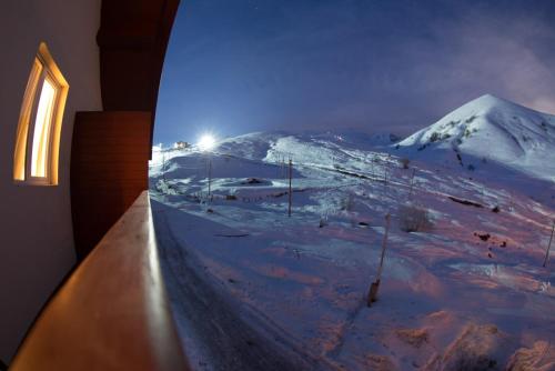 a room with a view of a snow covered mountain at Hotel Deka Gudauri in Gudauri