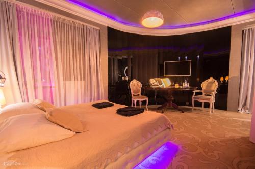 a bedroom with a bed with a desk and chairs at Hotel Ramka & Restaurant & Wine Bar in Poznań