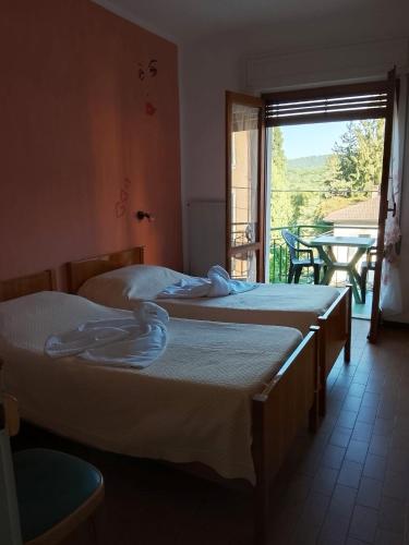 three beds in a room with a table and a window at Vittoria 1920 - hotel restaurant apartaments in Marzio