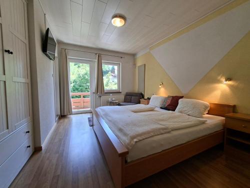 a bedroom with a large bed and a large window at GRÜNER HEINRICH - Bett&Frühstück in Oberaichwald