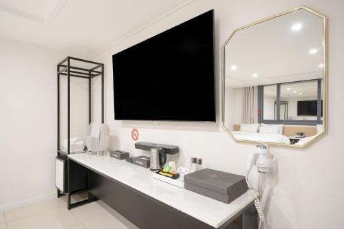 a room with a large mirror and a tv on the wall at Rium Hotel in Mokpo