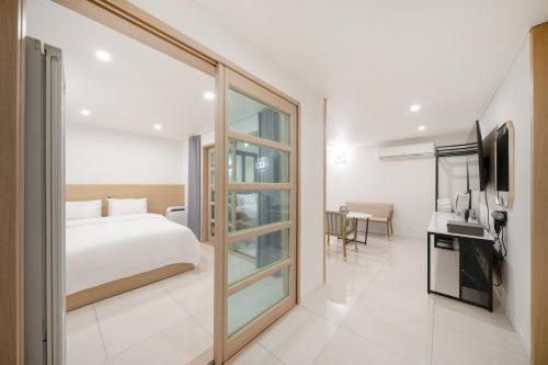 a bedroom with a bed and a tv in a room at Rium Hotel in Mokpo