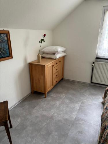 a room with a bed and a dresser with a flower on it at Dachstudio in Kaiseraugst