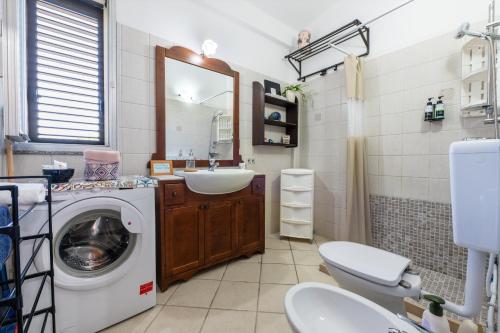 a bathroom with a washing machine and a sink at Casa Villa Aury in Cefalù