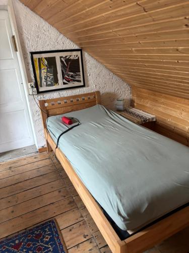 a bed in a wooden room with a door at Dachstudio in Kaiseraugst