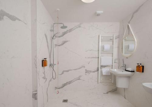 a white bathroom with a shower and a sink at Bishop's Gate Hotel in Derry Londonderry