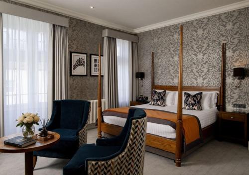a hotel room with a bed and a table and chairs at Bishop's Gate Hotel in Derry Londonderry