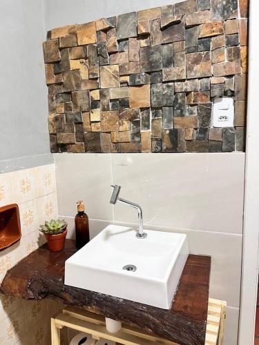 a bathroom with a sink and a stone wall at Villa Dona Jaca - Casa da Mata - Casa 02 in Socorro