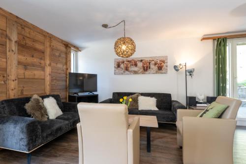 a living room with two couches and a table at Chalet Ravenstein in Fiesch