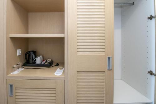 a walk in closet with a cupboard and a sink at Kamari Beach in Lartos