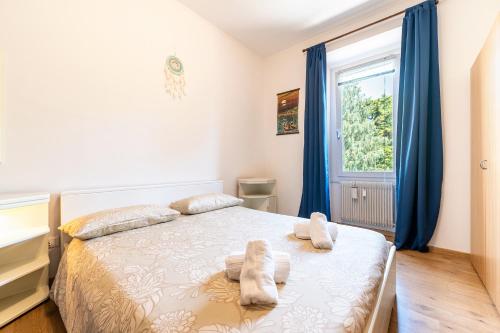 a bedroom with a bed with blue curtains and a window at Arco Park View By Immobilux in Arco